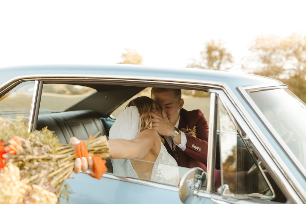 Newly wed couple kissing inside a vintage car in Mt Home Arkanas